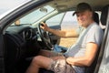 Handsome mature man sits behind the wheel in his car in nature