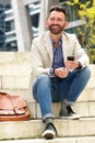 Handsome mature man sitting outdoors with cellphone Royalty Free Stock Photo