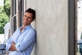 Handsome mature man smiling and leaning against wall Royalty Free Stock Photo