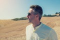 Handsome mature man walking in tuscany fields, summer landscape in Tuscany with fields, blue sky and moutains, Italy Royalty Free Stock Photo