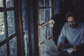 Handsome mature man working with laptop computer in the dark inside a cozy wooden cabin. Concept of smart working and technology Royalty Free Stock Photo