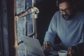 Handsome mature man working with laptop computer in the dark inside a cozy wooden cabin. Concept of smart working and technology Royalty Free Stock Photo