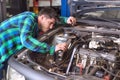 Handsome mechanic talking on the phone while repairing a car . Royalty Free Stock Photo