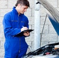 Handsome mechanic writing on a clipboard Royalty Free Stock Photo