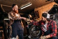 handsome mechanics making bro fist at motorcycle