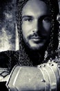 Portrait of handsome medieval knight in suit of armour with beard and blue eyes looking at camera Royalty Free Stock Photo
