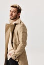 handsome men in beige coat model sweater light background Royalty Free Stock Photo