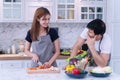 Handsome man and cheerful woman cooking organic vegetable salad healthy food in modern kitchen lifestyle meal preparation at Royalty Free Stock Photo