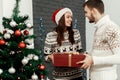 Handsome man giving christmas present to his beautiful woman in Royalty Free Stock Photo