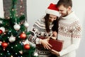 Handsome man giving christmas present to his beautiful woman in Royalty Free Stock Photo
