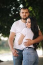 Handsome man with his gorgeous girlfriend. Happy couple walking along the embabkment. Green background