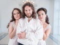 Man in medieval costume and two beautiful woman in old-fashioned negligee Royalty Free Stock Photo