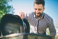 Handsome man preparing barbecue for friends. man cooking meat on barbecue - Chef putting some sausages and pepperoni on Royalty Free Stock Photo