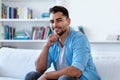 Handsome mexican hipster man with beard relaxing on couch