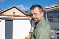 handsome middle age caucasian man smiling in garden near wood hut house Royalty Free Stock Photo