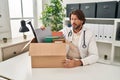 Handsome middle age doctor man holding box with items skeptic and nervous, frowning upset because of problem Royalty Free Stock Photo