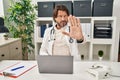 Handsome middle age doctor man working at the clinic doing stop sing with palm of the hand Royalty Free Stock Photo