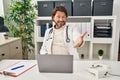 Handsome middle age doctor man working at the clinic smiling friendly offering handshake as greeting and welcoming Royalty Free Stock Photo