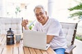 Handsome middle age hispanic man with grey hair and glasses working using computer laptop at home Royalty Free Stock Photo