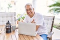 Handsome middle age hispanic man with grey hair and glasses working using computer laptop at home Royalty Free Stock Photo