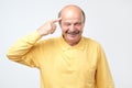 Senior man smiling pointing to head with one finger, great idea or thought Royalty Free Stock Photo