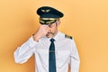 Handsome middle age man with grey hair wearing airplane pilot uniform tired rubbing nose and eyes feeling fatigue and headache Royalty Free Stock Photo