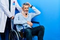 Handsome middle age man with grey hair on wheelchair wearing cervical collar confuse and wonder about question Royalty Free Stock Photo