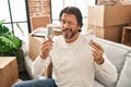 Handsome middle age man holding led lightbulb and incandescent bulb winking looking at the camera with sexy expression, cheerful Royalty Free Stock Photo