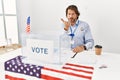 Handsome middle age man sitting at voting stand looking at the camera blowing a kiss with hand on air being lovely and sexy