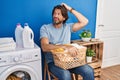 Handsome middle age man waiting for laundry confuse and wonder about question