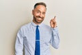 Handsome middle age man wearing business shirt and tie with a big smile on face, pointing with hand and finger to the side looking Royalty Free Stock Photo