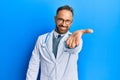 Handsome middle age man wearing doctor uniform and stethoscope smiling friendly offering handshake as greeting and welcoming Royalty Free Stock Photo