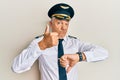 Handsome middle age mature man wearing airplane pilot uniform doing thumbs up and down, disagreement and agreement expression