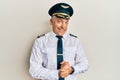 Handsome middle age mature man wearing airplane pilot uniform with hands together and crossed fingers smiling relaxed and cheerful Royalty Free Stock Photo