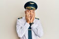 Handsome middle age mature man wearing airplane pilot uniform tired hands covering face, depression and sadness, upset and Royalty Free Stock Photo