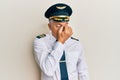 Handsome middle age mature man wearing airplane pilot uniform tired rubbing nose and eyes feeling fatigue and headache Royalty Free Stock Photo