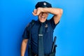 Handsome middle age mature man wearing police uniform covering eyes with arm smiling cheerful and funny Royalty Free Stock Photo