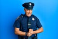 Handsome middle age mature man wearing police uniform with hands together and crossed fingers smiling relaxed and cheerful Royalty Free Stock Photo