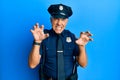 Handsome middle age mature man wearing police uniform smiling funny doing claw gesture as cat, aggressive and sexy expression Royalty Free Stock Photo