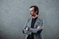 handsome middle aged businessman in eyeglasses and wristwatch standing with crossed arms