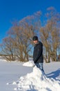 Handsome middle-aged caucasian man cleans snow on household plot