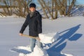 Handsome middle-aged caucasian man cleans snow on household plot