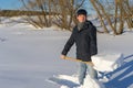 Handsome middle-aged caucasian man cleans snow on household plot