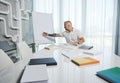 Handsome middle aged Caucasian man, successful business person, entrepreneur sitting at a table and making notes on a flip chart Royalty Free Stock Photo