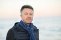 Handsome middle-aged man at the beach. Attractive happy smiling mid adult male model posing at seaside, sunset o sunrise. Outdoor Royalty Free Stock Photo