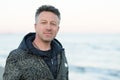 Handsome middle-aged man at the beach. Attractive happy smiling mid adult male model posing at seaside, sunset o sunrise. Outdoor Royalty Free Stock Photo