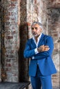 A handsome middle-aged man in a blue formal suit poses on a gray background. Portrait of a businessman. A handsome middle-aged man Royalty Free Stock Photo