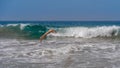 handsome middle aged man diving into a wave in the blue sea Royalty Free Stock Photo