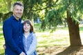 Handsome middle-aged man in park with his son. Attractive mid adult male model posing outddor with teen boy Royalty Free Stock Photo