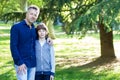 Handsome middle-aged man in park with his son. Attractive mid adult male model posing outddor with teen boy Royalty Free Stock Photo